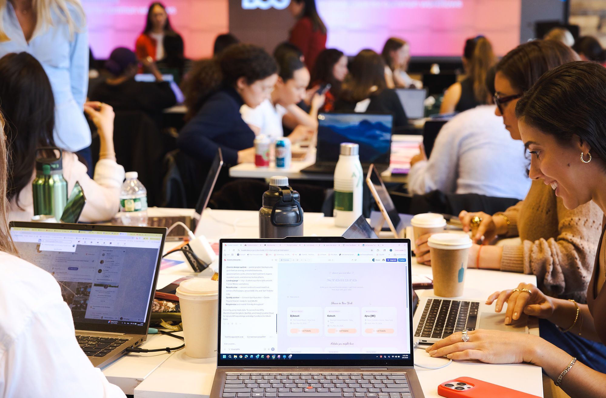 Women building apps on laptops at a Model Behavior build event