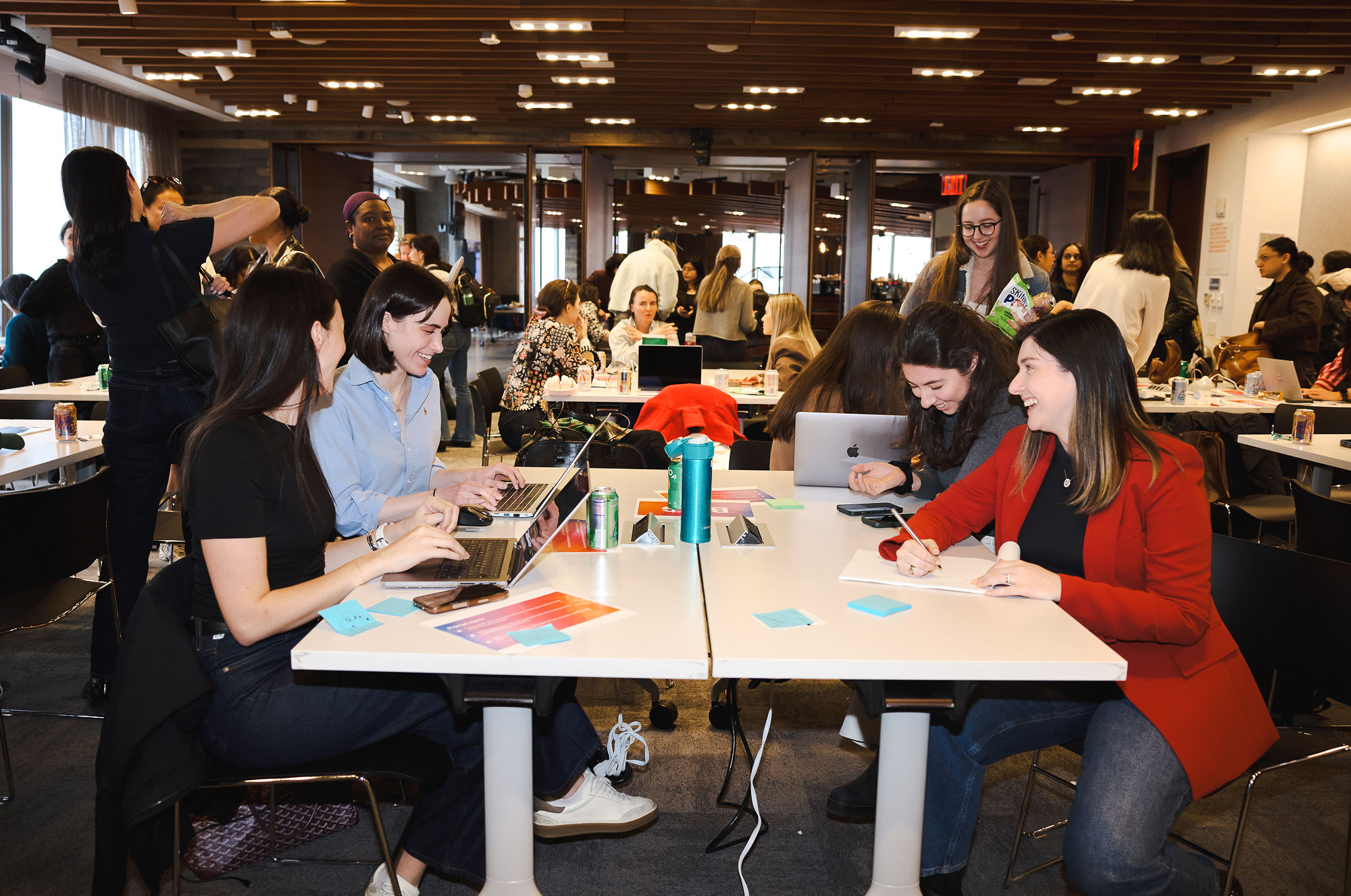 Women coworking and laughing over coffee at Model Behavior